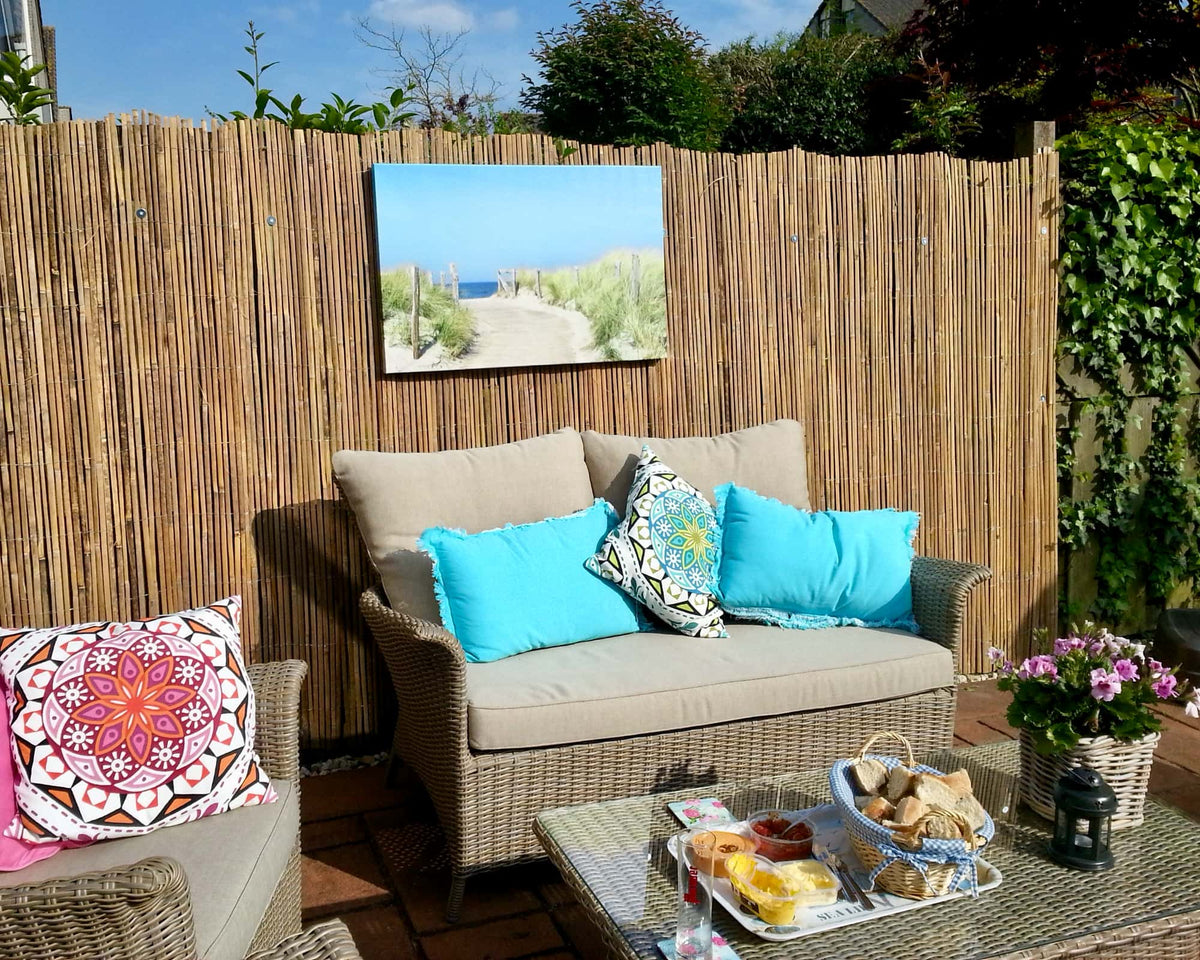 Gespleten bamboematten tegen hekwerk voor een duurzame en tropische erfafscheiding