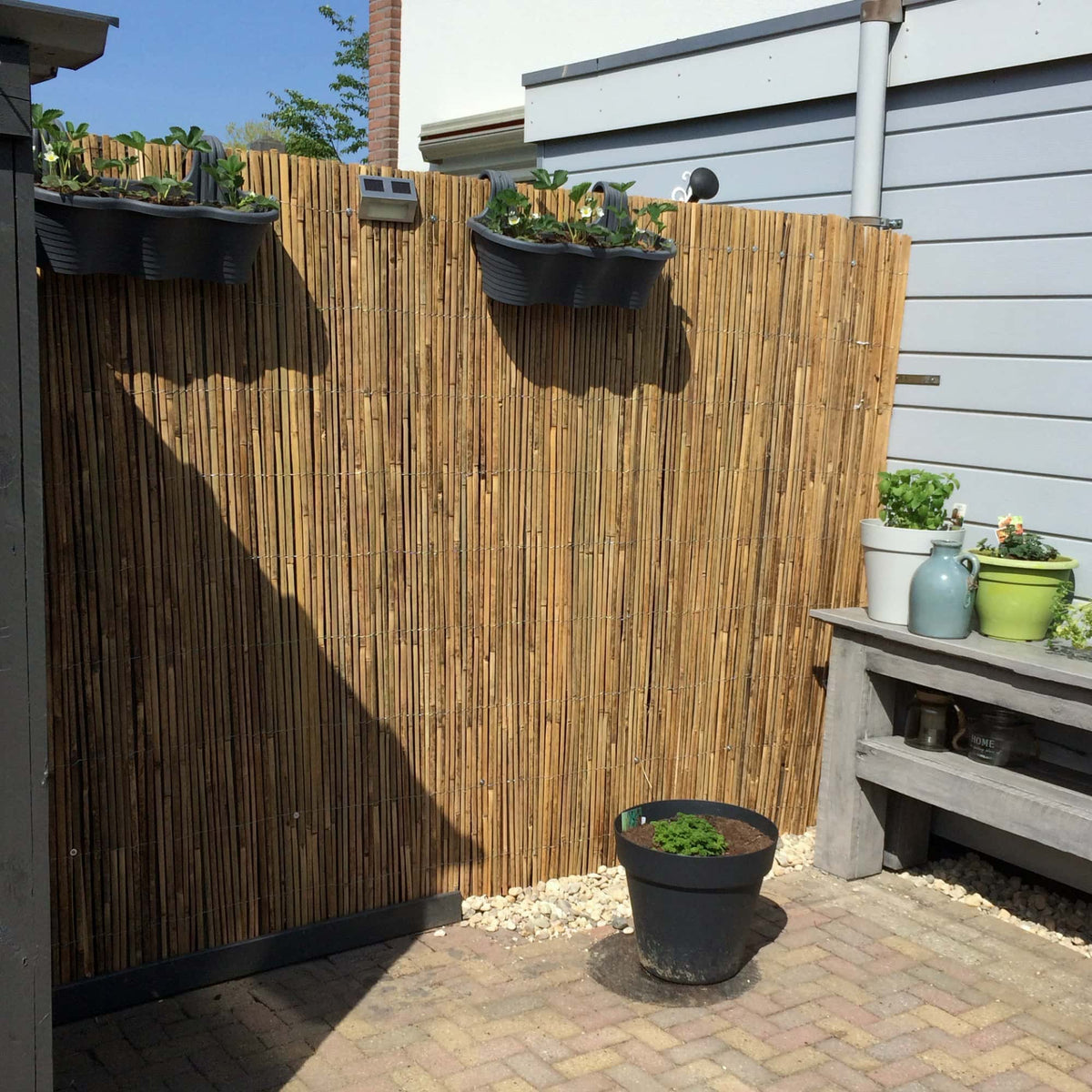 Gespleten bamboemat 500 x 180 cm tegen bestaande schutting