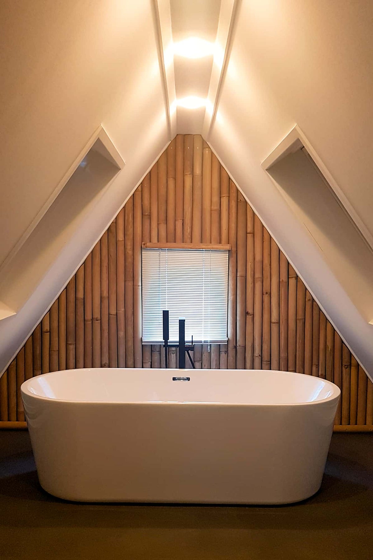 Halfronde bamboe palen als muurbekleding in badkamer