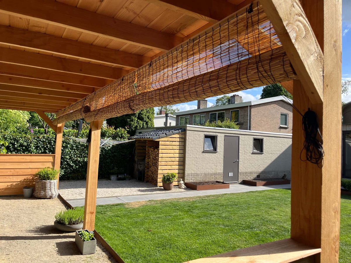 rieten rolgordijnen in overkapping in de tuin