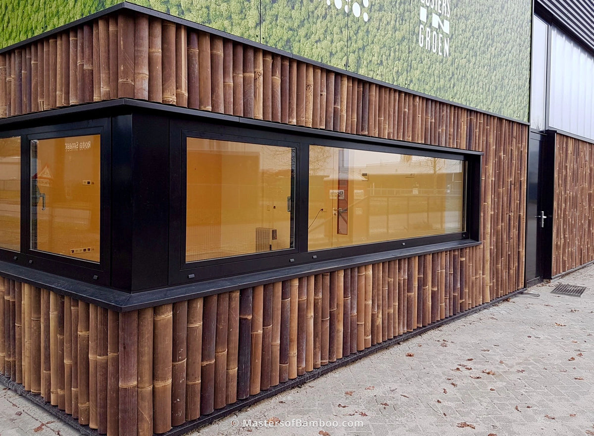 Halfronde donkere bamboepalen tegen buitenmuur