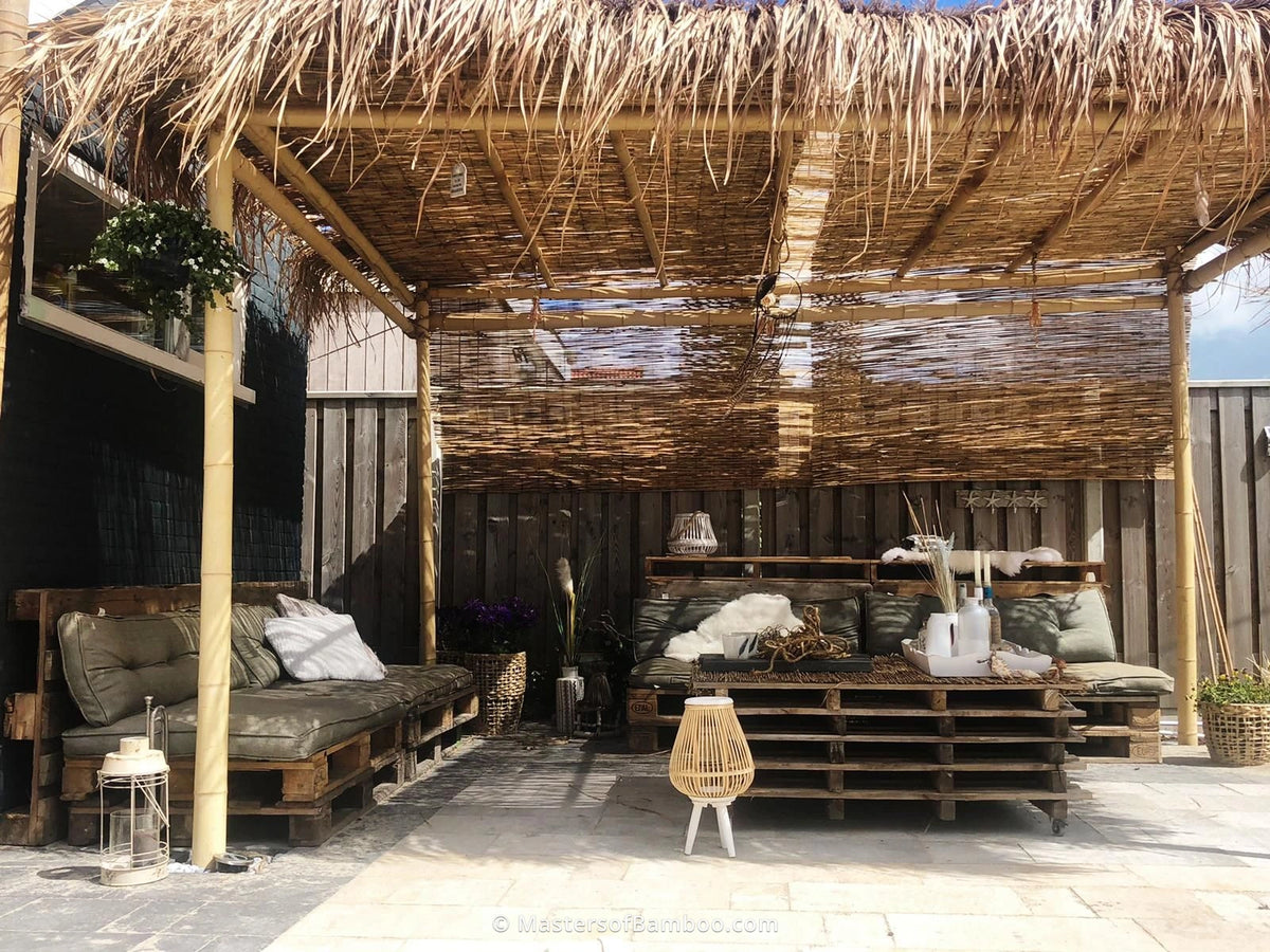 bamboe pergola lounge hoek met rietmat en strodak