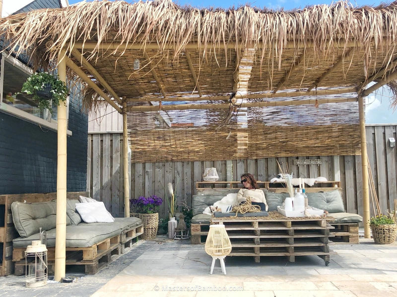 loungeplek tuin onder bamboe pergola